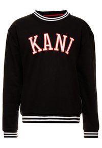 Black sweatshirt with white and red "KANI" text on front, featuring black and white striped collar, cuffs, and waistband.