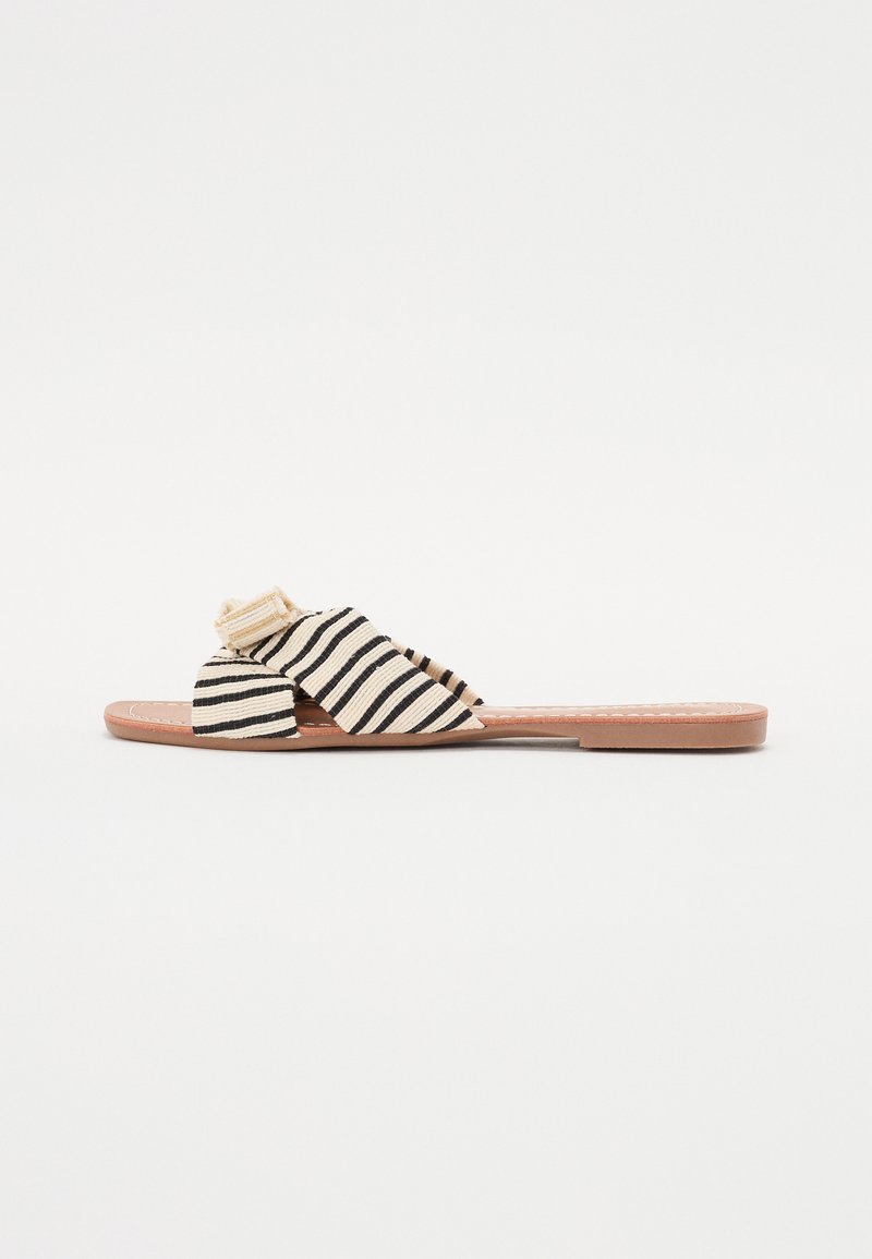 Strippede sandaler med vævet stof i sort og creme, der har en knyttet detalje på overdelen og en flad tan syntetisk sål.