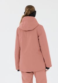 Veste rose résistante à l'eau avec capuche, présentant une texture lisse et des accents noirs, conçue pour les activités en plein air.