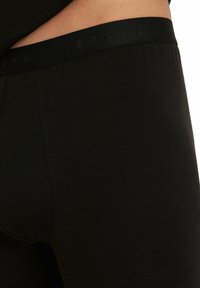 Zwarte leggings met een soepele textuur en FALKE-branding op de elastische tailleband, met een aansluitend ontwerp en naden aan de zijkanten.
