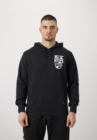 Sudadera negra con capucha, que presenta un logo blanco de "PUMA HOOPS" y una gráfica de baloncesto en el pecho. Incluye un bolsillo delantero y puños de canalé.