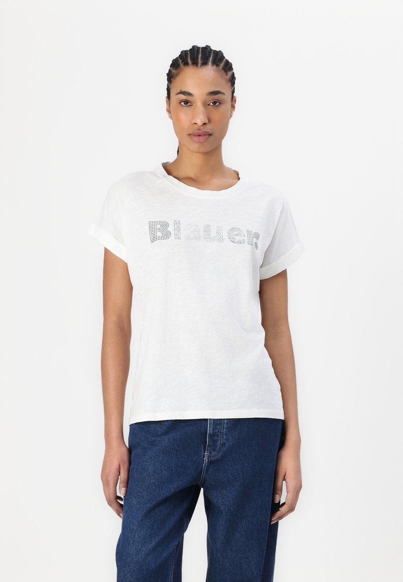 Camiseta blanca con mangas cortas enrolladas, que presenta un logo de "Blauer?" en gris con puntos en el centro. Suave, ligera y con un ajuste casual.