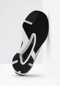Sola di scarpa atletica in bianco e nero con gomma testurizzata, una superficie liscia e dettagli ventilati; progettata per la presa e il comfort.