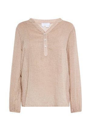 Long-sleeve, beige blouse made from textured fabric, featuring a V-shaped collar, button placket, and slight gathering at the cuffs.