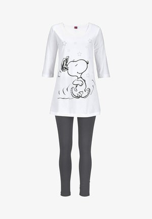 White tunic top with black Snoopy graphic and stars, paired with dark gray leggings. Features a rounded neckline and three-quarter sleeves.