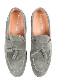 Mocassini in suede grigi con dettagli in frange, cuciture decorative e interno liscio. Le etichette indicano "Made in Italy". Design con punta piatta e arrotondata.