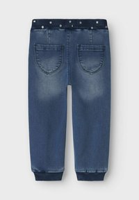 Joggers de mezclilla en azul oscuro con una cintura acanalada decorada con acentos florales. Cuenta con dos bolsillos traseros y puños ajustados.