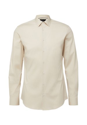 Beżowa koszula na długi rękaw zapinana na guziki, z klasycznym kołnierzykiem, dopasowanym krojem i białymi guzikami z przodu.