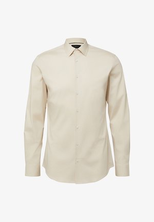 Beżowa koszula na długi rękaw zapinana na guziki, z klasycznym kołnierzykiem, dopasowanym krojem i białymi guzikami z przodu.