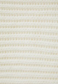 Texture bianco intrecciato realizzato in morbido filato, con un motivo a zigzag costante e una leggera lucentezza, creando una superficie accogliente e tattile.