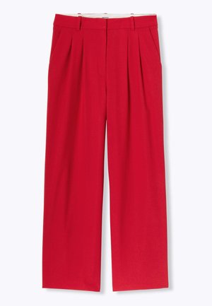 Pantalons larges rouges à taille haute, dotés de plis avant et de poches latérales. Fabriqués en tissu lisse, offrant une tenue structurée.