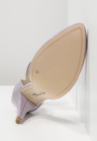 Chaussure à talon haut en cuir verni violet avec un bout pointu et un talon fin. L'intérieur est lisse avec une semelle intérieure beige portant la mention "36" et le logo de la marque.