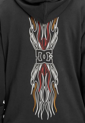 Czarna bluza z kapturem z odważnym wzorem graficznym na plecach, z białymi, czerwonymi i pomarańczowymi, płomiennymi wzorami wokół centralnego logo.