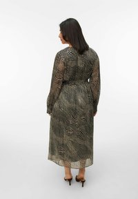 Robe à motif noir et beige en tissu transparent, à manches longues, taille cintrée et design longueur cheville avec une texture à rayures ondulées.