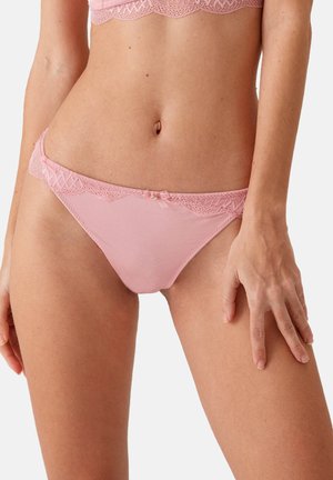 Lichtroze ondergoed met kantafwerking langs de tailleband, een kleine strikaccent aan de voorkant en een gladde stofstructuur.