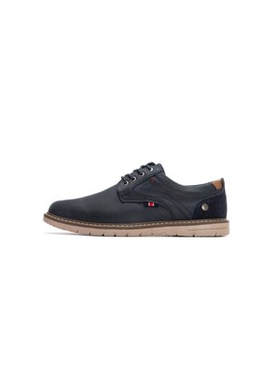 Zapatos de vestir de cuero azul marino con punta redonda, costuras tonales y una suela de goma beige. Cuenta con detalles de logo y acentos texturizados en contraste.