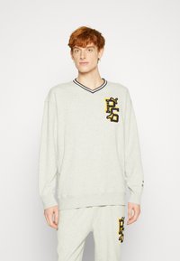 Hellgrau sweatshirt mit langen Ärmeln, V-Ausschnitt, geripptem Kragen und gesticktem "PS"-Logo in Gelb und Schwarz auf der linken Brust.
