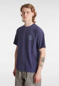 Marinblå bomulls-t-shirt med rund halsringning och korta ärmar, med en Vans-logotyp broderad på vänster bröst.