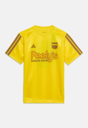 Geel sportshirt met bruine strepen op de mouwen, "Peely's Banana Stand" en "Fortnite" logo's en het Adidas-embleem op de borst.