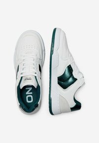 Sneakers bianchi con dettagli verdi, tomaia in pelle e sintetico, punta rotonda, design perforato, suola in gomma e distintivo marchio "ONLX" all'interno.