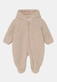 Combinaison bébé en polaire beige avec une capuche, zip frontal, manches longues et pieds fermés ; texture douce avec une finition en peluche.