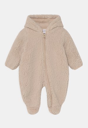Beżowy polarowy kombinezon dla niemowląt z kapturem, zamkiem błyskawicznym z przodu, długimi rękawami i zakrytymi stopami; miękka tekstura z puszystym wykończeniem.