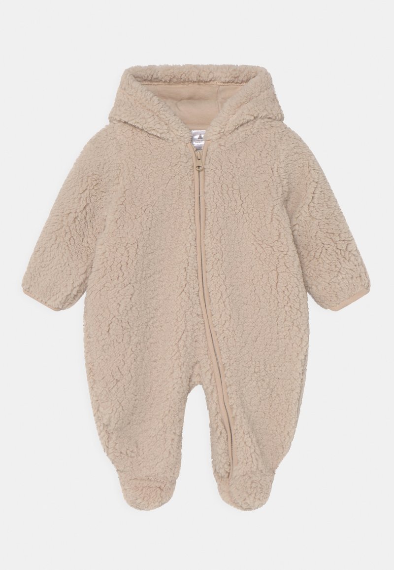 Combinaison bébé en polaire beige avec une capuche, zip frontal, manches longues et pieds fermés ; texture douce avec une finition en peluche.