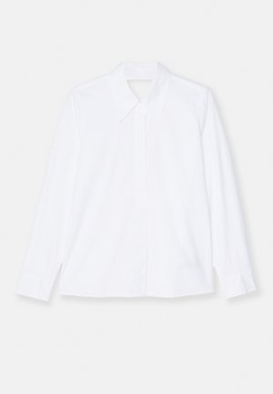 Chemise blanche à manches longues en tissu léger. Dotée d'un col classique, d'une fermeture à boutons à l'avant et de poignets avec de légers plis. Design épuré.