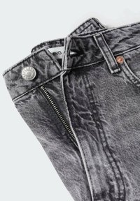 Jean noir acid-wash avec fermeture éclair partiellement ouverte, bouton en métal, passants de ceinture et étiquette de marque visible à l'intérieur de la ceinture.