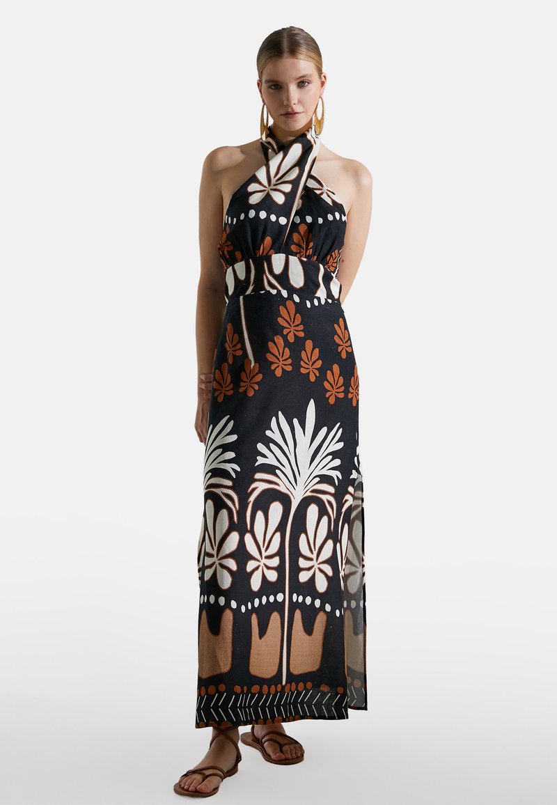 Vestido maxi con cuello halter, base negra, motivos florales en blanco y naranja, cintura entallada y falda fluida con detalles intrincados en el borde.