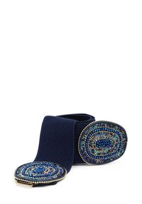 Cintura elastica blu con due fibbie circolari in tonalità blu e argento, caratterizzate da intricati motivi a spirale. Texture morbida e design flessibile.