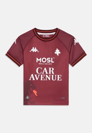 Koszulka Maroon FC Metz z krótkimi rękawami, okrągłym kołnierzykiem, białymi logo i kontrastowymi pomarańczowymi akcentami. Posiada teksturowany materiał i wyraźny napis.