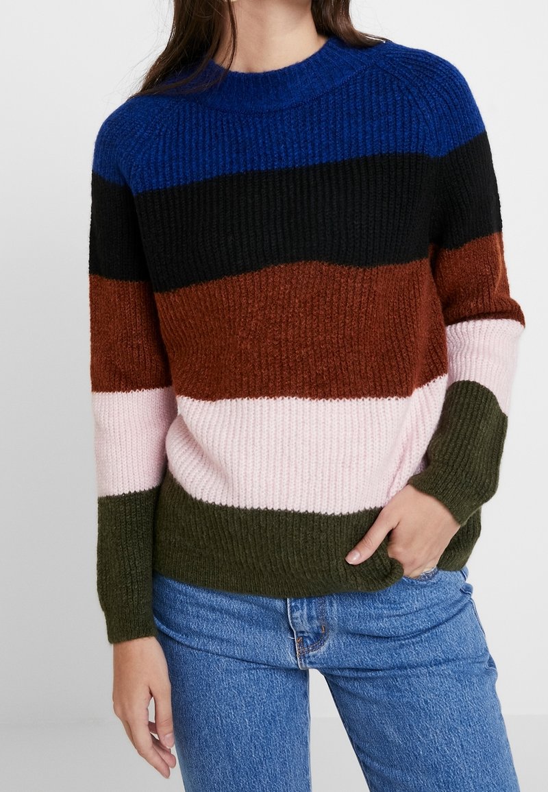 Sweter dziergany z paskowym wzorem w kolorach niebieskim, czarnym, rdzawym, różowym i zielonym. Charakteryzuje się prążkowaną fakturą i okrągłym dekoltem.