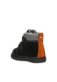 Schwarze und graue Stiefel mit einem strukturierten Stoffobermaterial, orangefarbener Wildlederakzent, seitlichen Riemen und einer gerippten schwarzen Gummisohle.