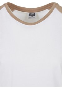 Hvit T-skjorte med brune skulderdetaljer, rund hals, laget av myk bomull, med et merke som sier "URBAN CLASSICS" og størrelse XS.