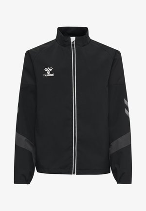 Chaqueta deportiva negra con cuello alto, cierre frontal de cremallera, ribete blanco y logo en el pecho. Presenta acentos grises en las mangas.