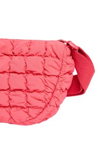 Polstret pink crossover taske med quiltet tekstur, der har en bred, tekstureret rem og rund form. Lynlåslukningen er ikke synlig.