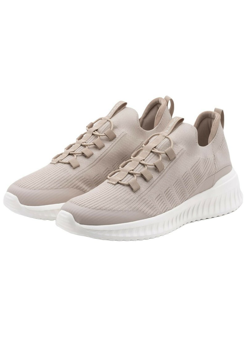Scarpe da ginnastica beige con tomaia in tessuto lavorato a maglia, lacci elastici e suola bianca ammortizzata. Punta rotonda e linguetta sul retro per una facile calzata.