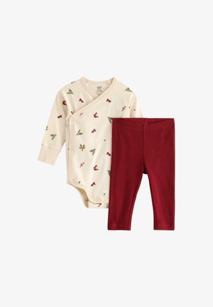 Bavlněný kojenecký overal v krémové barvě s různými potisky malých zvířat a rostlin, v kombinaci s červenými žebrovanými legínami, které jsou navrženy pro pohodlí.