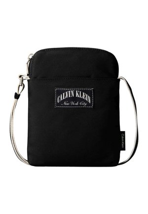 Geantă crossbody neagră Calvin Klein cu bretea albă reglabilă și etichetă frontală cu inscripția "Calvin Klein New York City."