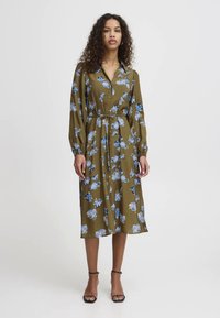 Vestido abotoado em verde-oliva com padrão floral azul, mangas longas, cintura com cinto e comprimento até à metade da panturrilha. Tecido suave e corte descontraído.
