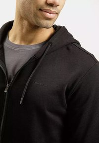 Czarny bluza z zamkiem błyskawicznym wykonaną z teksturowanej tkaniny, z szarym podszewką i małym logo na klatce piersiowej. Casualny i funkcjonalny design.