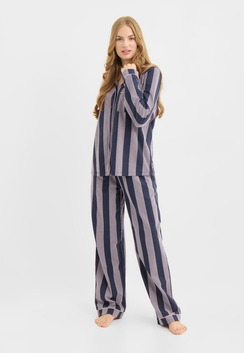 Marineblåt og pink stribet pyjamassæt i let stof, med en langærmet knappet top og løstsiddende bukser.