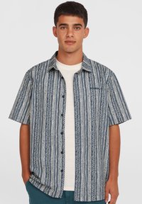 Kortærmet, knappet skjorte med et blåt og hvidt stribet mønster og indviklede cirkulære designs. Stoffet har en let tekstur.