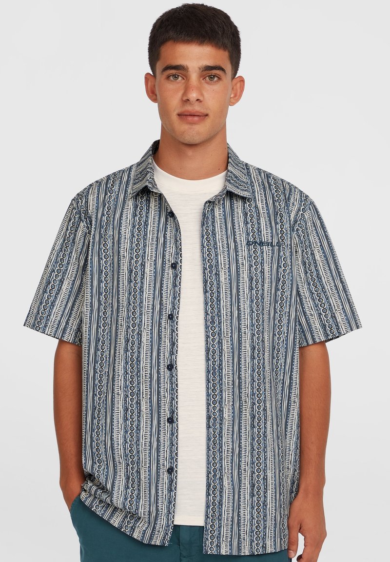Kortærmet, knappet skjorte med et blåt og hvidt stribet mønster og indviklede cirkulære designs. Stoffet har en let tekstur.
