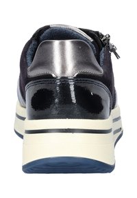 Basket en suede noire avec un talon noir brillant et des accents argentés, présentant une surface lisse et une semelle texturée. Détail de fermeture éclair à l'arrière.