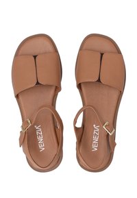 Bruine leren sandalen met een platte zool, open teen en een gespsluiting. Heeft een gladde textuur en een minimalistisch ontwerp.