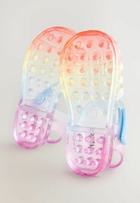 Permatomi sandalai, pereinantys nuo oranžinės iki rožinės spalvos, su ant pado esančiomis iškilusiomis apskritim formos dėmėmis ir mėlyna akcentine diržele.