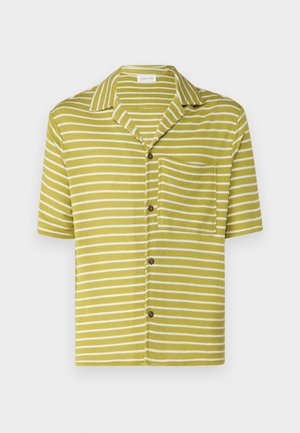 Short-sleeve shirt in olive green with white horizontal stripes, featuring a collar, a front pocket, and brown buttons. Textured fabric.