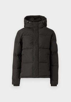 Schwarze Pufferjacke mit Reißverschluss vorne, Kapuze und gerippten Bündchen; verfügt über gesteppten Bereiche zur Isolierung und einem Logo-Patch am Ärmel.